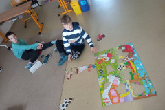 Žáci na podlaze skládají velké puzzle.