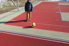 Chlapec na školním hřišti s balonem.