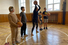 Paní učitelka ukazuje, jak házet medicimbalem.