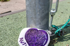 Namalovaný kamínek "autismus" na školním hřišti.