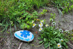 Namalovaný kamínek "vnímám svět jinak" na školním hřišti.