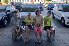 Žáci ve městě na lavičce.