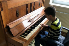 Chlapec hraje na klavír.