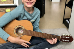 Chlapec hraje na kytaru.